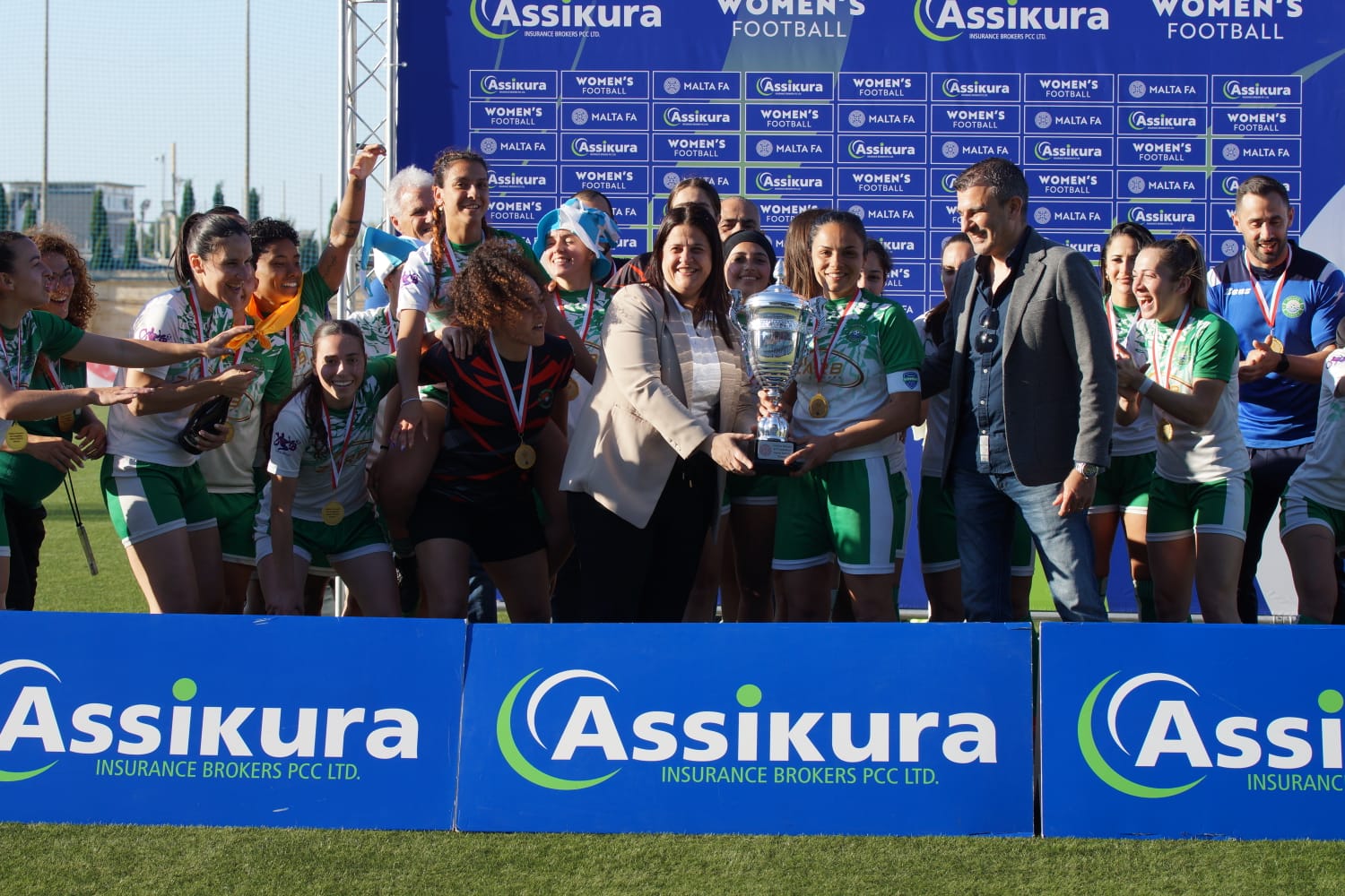 Malta FA General Secretary Maria Azzopardi and Assikura Insurance Brokers PLC Managing Director present the trophy to Mġarr United captain Abigail Camilleri - (c) Lara Schembri